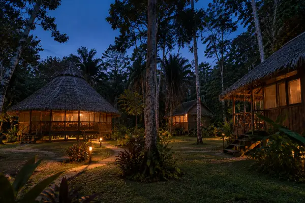 Iquitos ayahuasca retreat center at dusk, seen from the forest path